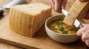 Scorza di Parmigiano Reggiano tagliata sopra una zuppa di verdure