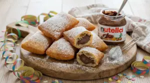 Bugie di Carnevale ripiene di Nutella, spolverate di zucchero a velo su tagliere con barattolo di crema al cacao